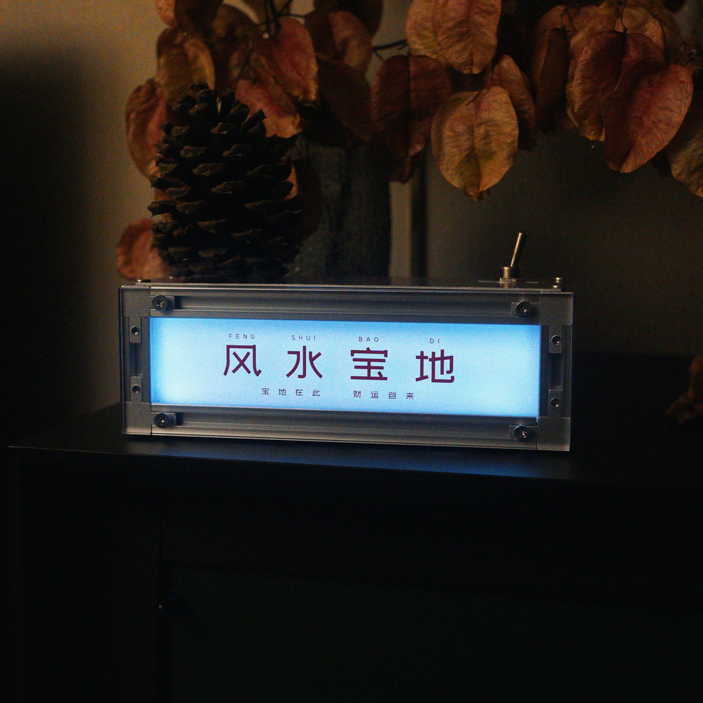 Lifestyle shot of the HushLume smart industrial light box illuminated in cool cyan blue, demonstrating the smart app RGB color-changing feature on a dark desk.