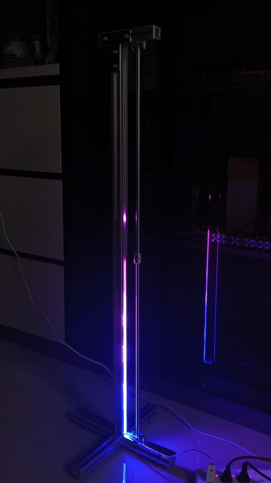 HushLume 3030 aluminum industrial RGB floor lamp casting a cool blue and purple neon glow with subtle mirror reflections in a dark room setup.