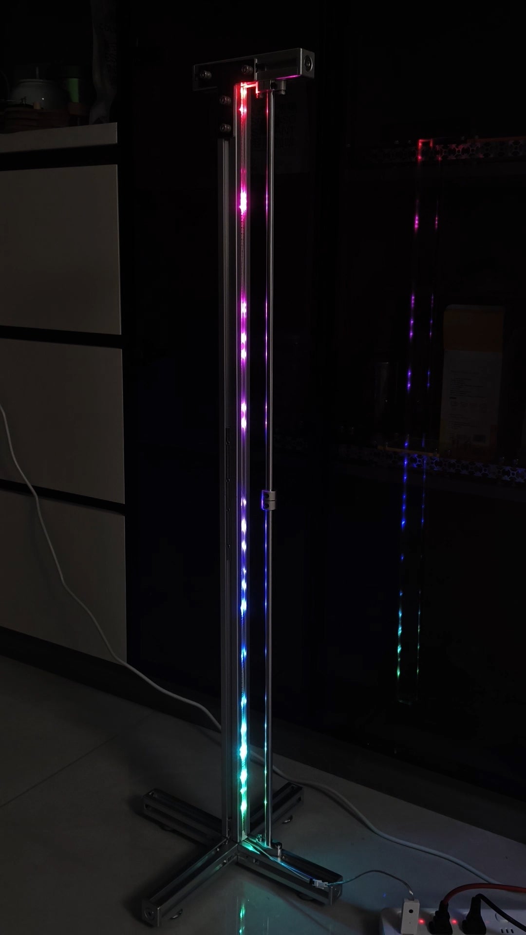 HushLume 3030 aluminum industrial RGB floor lamp demonstrating a segmented chasing light effect with addressable multi-color LED lighting in a dark room.