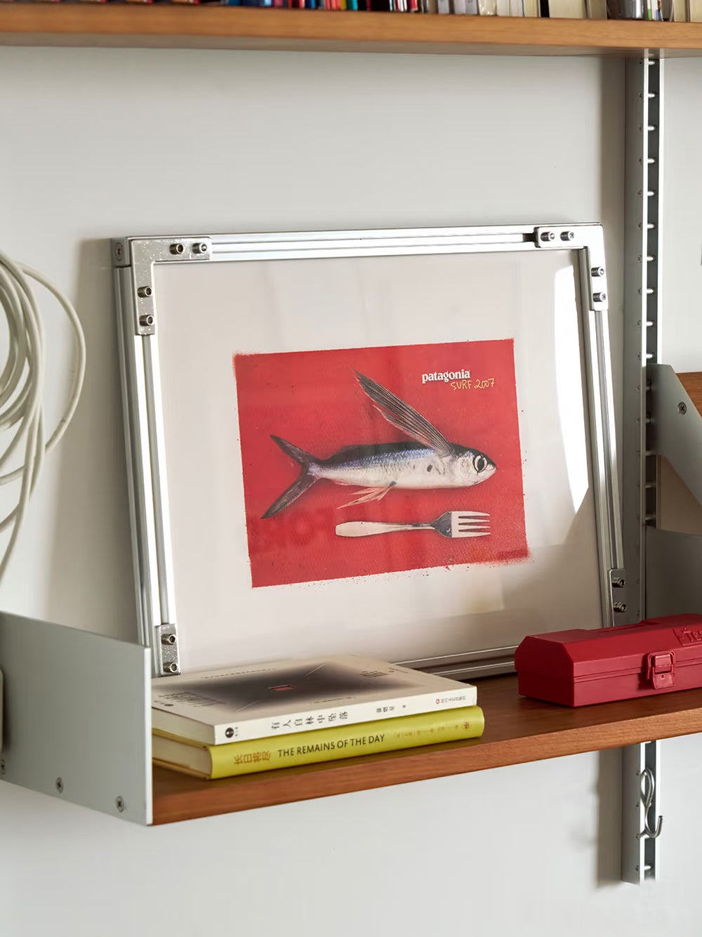Lifestyle shot of HushLume 2020 aluminum picture frame styled horizontally on a wooden wall shelf, creating a modern industrial home decor aesthetic.