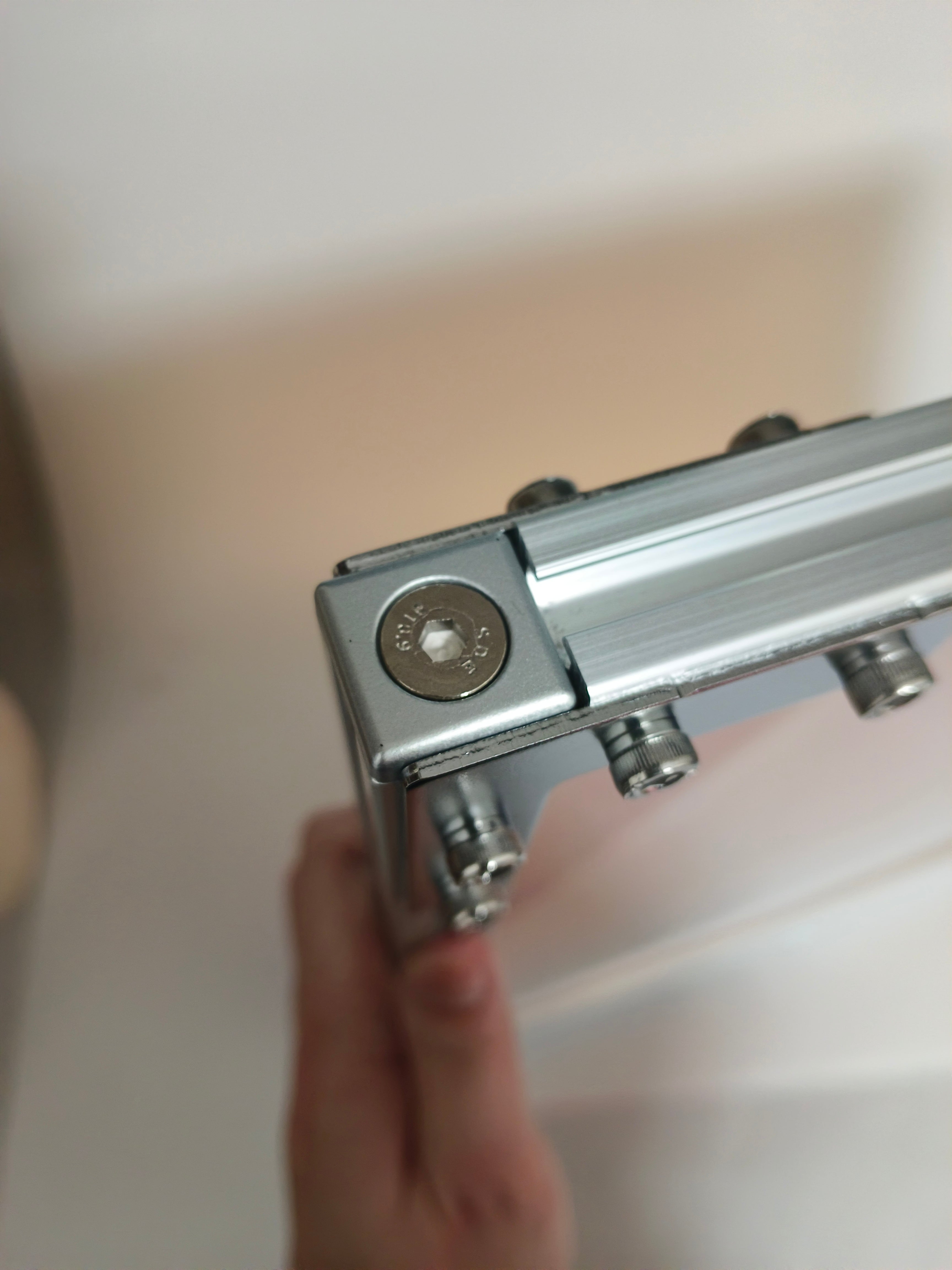 Close-up view of the corner joint mechanism on HushLume industrial aluminum frame, showing premium hex socket screws and precision engineering details.